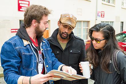 Nathan Wornian, AJ Friday, and Hazel Lozano discuss logistics for performing their theater piece in a U-District alley.
