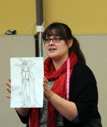 Picture of Jocelyn Fowler (BA '09) with one of her costume sketches.