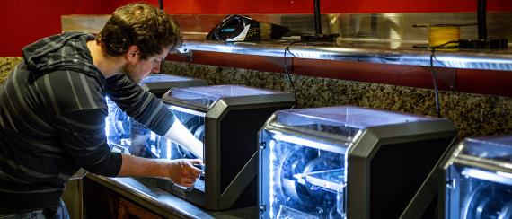 Graduate student making PPE with 3D printers