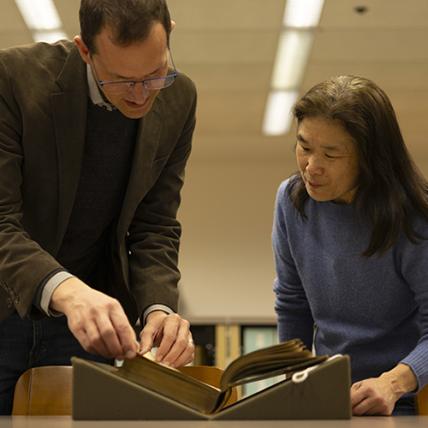 Scott Magelssen and Julie Tanaka look at an illustrated Shakespeare book donated to UW Libraries. 