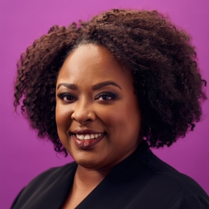 a woman smiling against a purple background