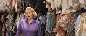 Portrait of Chante Hamann, standing in one of the School of Drama's storage rooms for costumes.