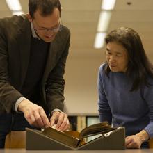 Scott Magelssen and Julie Tanaka look at an illustrated Shakespeare book donated to UW Libraries. 