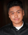 a man smirks in front of a black background