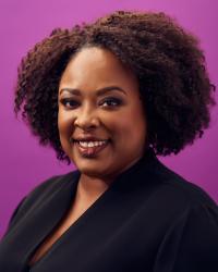 a woman smiling against a purple background