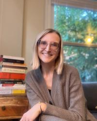 Smiling woman wearing glasses in front of books