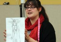 Picture of Jocelyn Fowler (BA '09) with one of her costume sketches.