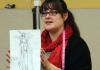 Picture of Jocelyn Fowler (BA '09) with one of her costume sketches.