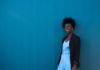Nikki Yeboah stands against a blue backgrou