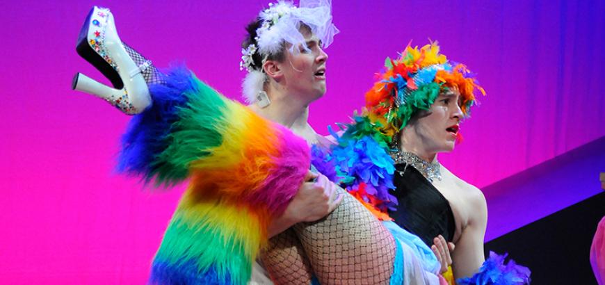 Two actors are portrayed in colorful clothing in the play "Once Upon a Time 6X in the West"