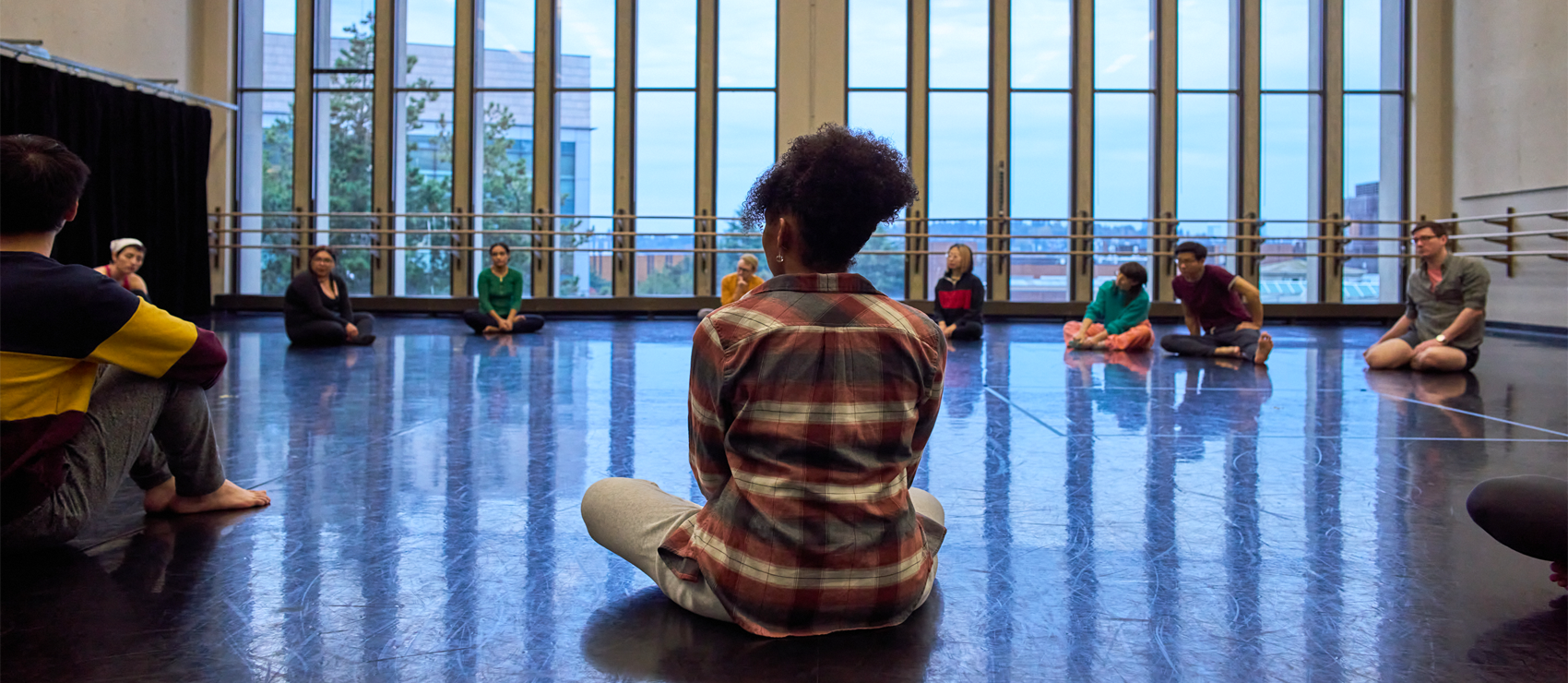Graduate drama students exploring movement and connection in a collaborative class setting