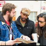 Nathan Wornian, AJ Friday, and Hazel Lozano discuss logistics for performing their theater piece in a U-District alley.