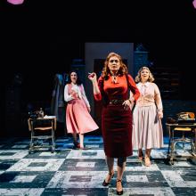 Three women look downstage