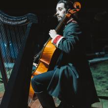 Musician playing cello on stage.