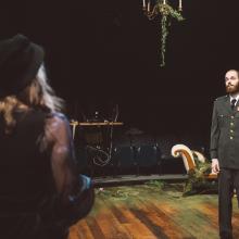 Man dressed in military garb gazes at young woman