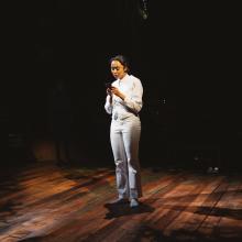 Young women reads something on stage.