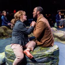 Man and woman sit together on rock