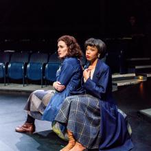 Women sit together on stage