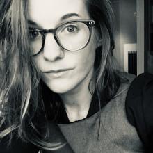 A white woman with glasses and blonde hair